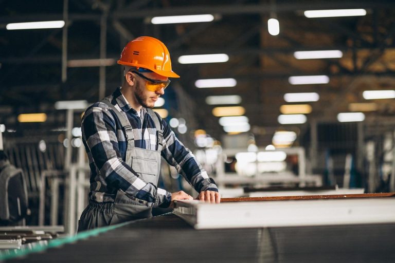 Werknemer draagt het juiste werkvest voor buitenwerk op de bouwplaats met goed zichtbare zakken en ergonomische pasvorm.